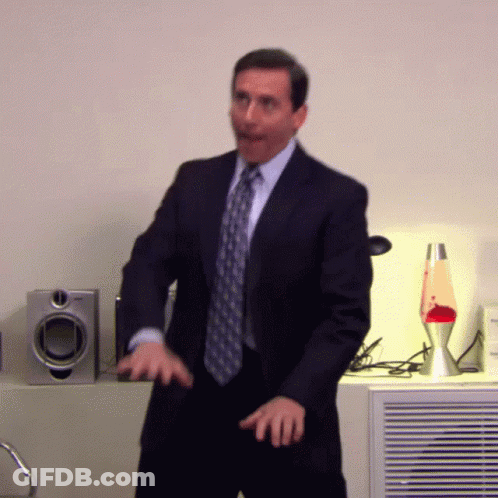 A Man In A Suit And Tie Is Dancing In A Room GIF