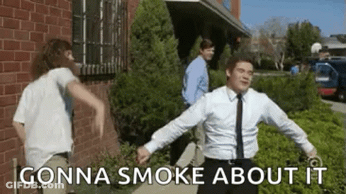 A Man In A Suit And Tie Is Dancing In Front Of A Brick Building While Another Man Looks On . GIF
