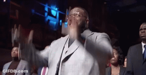 A Man In A Suit And Tie Is Dancing In Front Of A Crowd Of People GIF
