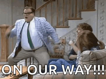 A Man In A Suit And Tie Is Dancing In Front Of A Group Of People . GIF