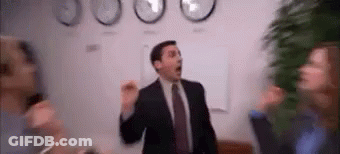 A Man In A Suit And Tie Is Dancing In Front Of A Group Of People . GIF