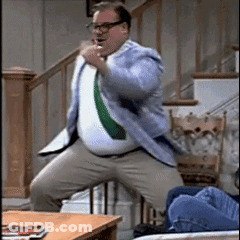A Man In A Suit And Tie Is Dancing In Front Of Stairs GIF