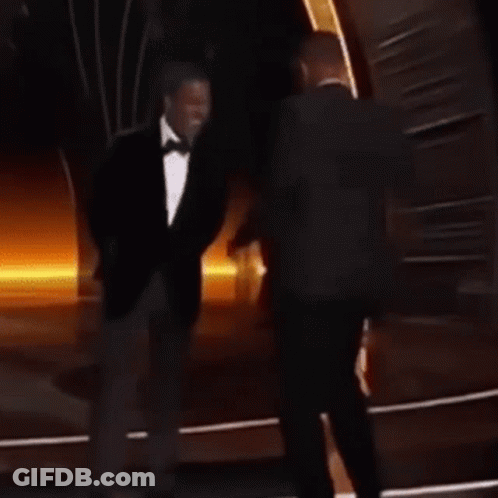 A Man In A Suit And Tie Is Dancing On A Stage . GIF