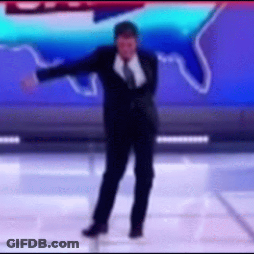 A Man In A Suit And Tie Is Dancing On A Stage In Front Of A Blue Background . GIF