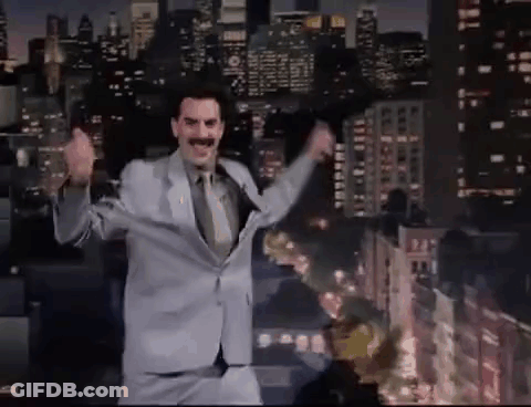 A Man In A Suit And Tie Is Dancing On A Stage In Front Of A City At Night . GIF