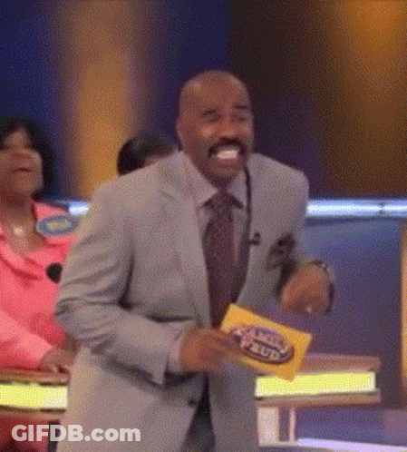 A Man In A Suit And Tie Is Dancing On A Stage While Holding A Yellow Card That Says Family Feud . GIF