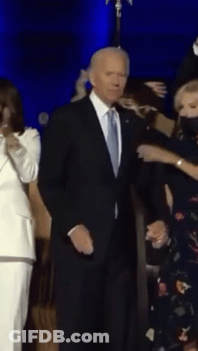 Man In Suit Dancing With Woman In Mask GIF