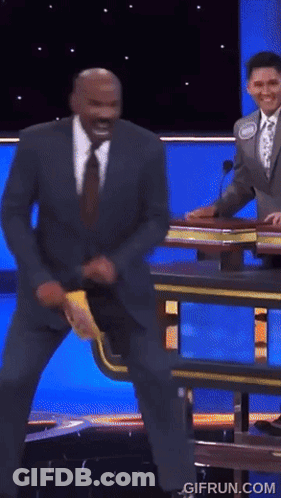 A Man In A Suit And Tie Is Dancing On A Stage With The Website Gifrun.com In The Lower Right Corner GIF