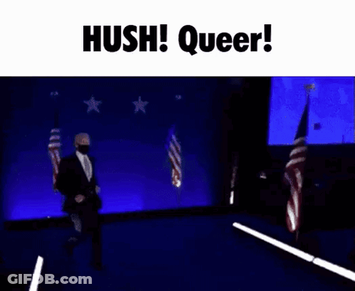 A Man In A Suit And Tie Is Dancing On A Stage With The Words Hush Queer Written Above Him . GIF