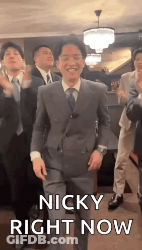 A Man In A Suit And Tie Is Dancing With A Group Of Men . GIF