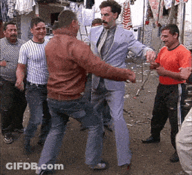 A Man In A Suit And Tie Is Dancing With Another Man GIF