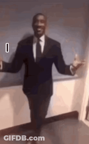 A Man In A Suit And Tie Is Dancing With His Arms Outstretched . GIF