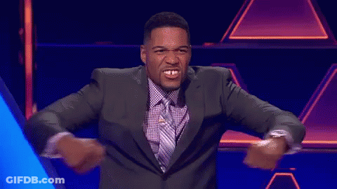 A Man In A Suit And Tie Is Dancing With His Arms Outstretched GIF
