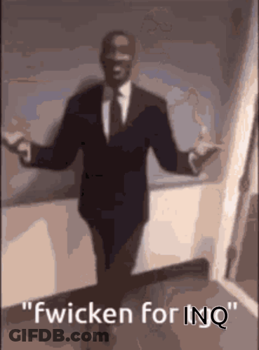 A Man In A Suit And Tie Is Dancing With The Words Fwicken For Inq Above Him GIF