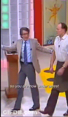 A Man In A Suit And Tie Is Dancing With The Words So You Are Now Under Arrest GIF