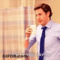 A Man In A Suit And Tie Is Drinking A Cup Of Coffee . GIF