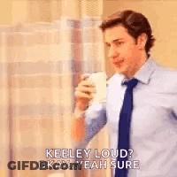 A Man In A Suit And Tie Is Drinking A Cup Of Coffee And Talking To Someone . GIF