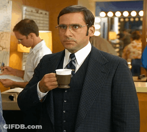 A Man In A Suit And Tie Is Drinking From A Cup GIF