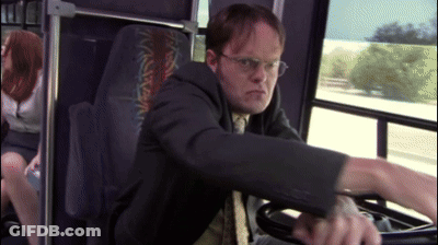 A Man In A Suit And Tie Is Driving A Bus With A Woman In The Back Seat GIF