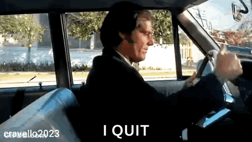 A Man In A Suit And Tie Is Driving A Car And Says I Quit GIF