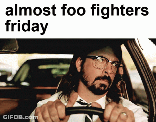 A Man In A Suit And Tie Is Driving A Car With The Words Almost Foo Fighters Friday Above Him GIF