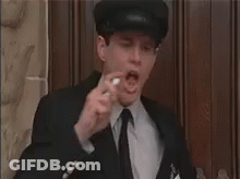 A Man In A Suit And Tie Is Eating A Candy Bar . GIF