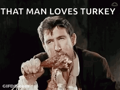 A Man In A Suit And Tie Is Eating A Turkey Leg . GIF