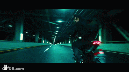 A Man In A Suit And Tie Is Fighting Another Man In A Dark Room With The Number 18+ On The Bottom Right GIF