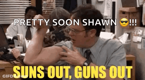 A Man In A Suit And Tie Is Flexing His Muscles In An Office While A Woman Looks On . GIF