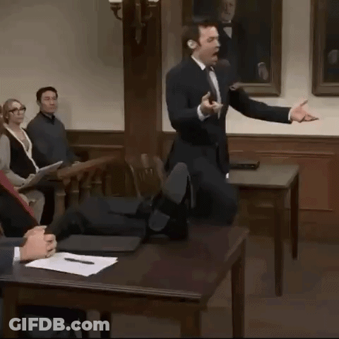 A Man In A Suit And Tie Is Giving A Presentation In Front Of A Group Of People GIF