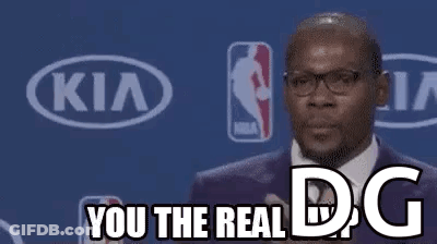 A Man In A Suit And Tie Is Giving A Speech At A Basketball Game . GIF