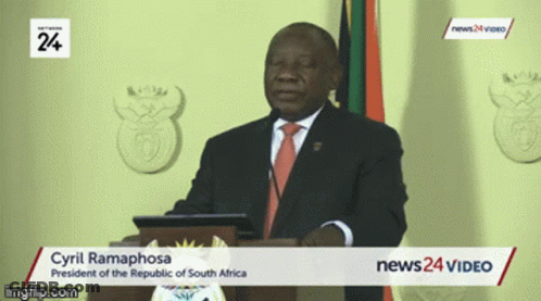 A Man In A Suit And Tie Is Giving A Speech At A News24 Video GIF