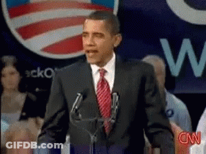 A Man In A Suit And Tie Is Giving A Speech In Front Of A Cnn Logo GIF