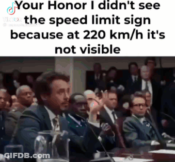 A Man In A Suit And Tie Is Giving A Speech In Front Of A Crowd Of People . GIF