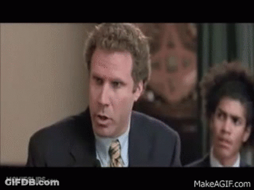 A Man In A Suit And Tie Is Giving A Speech In Front Of A Group Of People . GIF