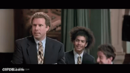 A Man In A Suit And Tie Is Giving A Speech In Front Of A Microphone . GIF