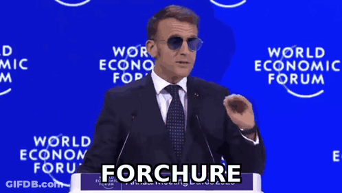 A Man In A Suit And Tie Is Giving A Speech In Front Of A World Economic Forum Sign GIF