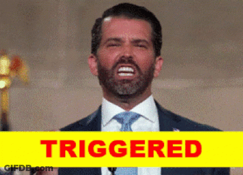 A Man In A Suit And Tie Is Giving A Speech Next To A Yellow Sign That Reads Triggered GIF