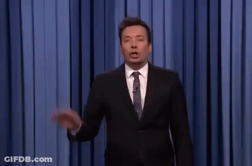 A Man In A Suit And Tie Is Giving A Speech On A Stage . GIF