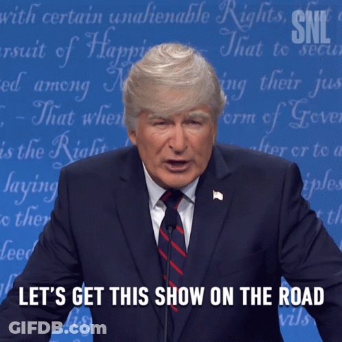 A Man In A Suit And Tie Is Giving A Speech With The Words Let 'S Get This Show On The Road Below Him GIF