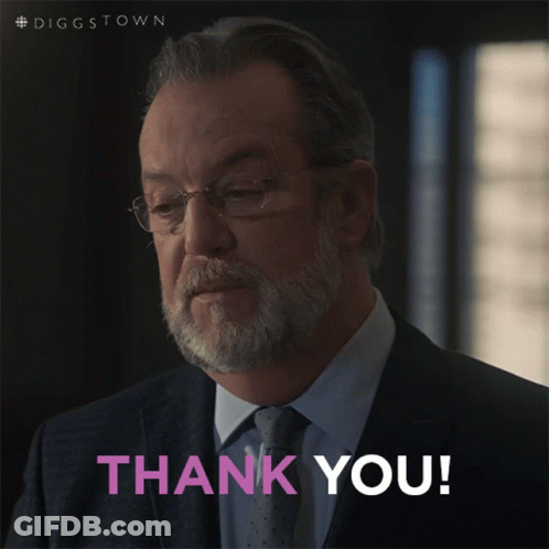 A Man In A Suit And Tie Is Giving A Thank You Sign GIF