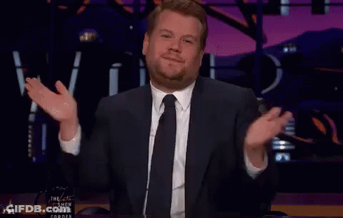 A Man In A Suit And Tie Is Giving A Thanks Gesture GIF