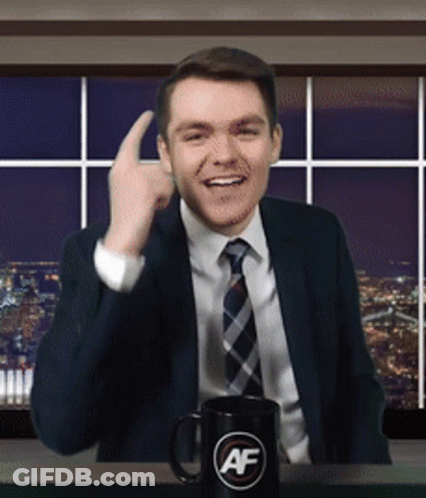 A Man In A Suit And Tie Is Giving A Thumbs Up Next To A Mug That Says Af GIF
