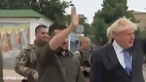 A Man In A Suit And Tie Is Giving The Middle Finger To Another Man GIF