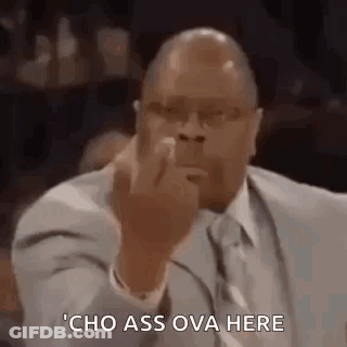 A Man In A Suit And Tie Is Giving The Middle Finger While Sitting In Front Of A Microphone . GIF