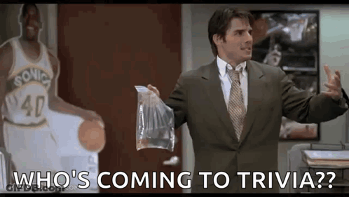 A Man In A Suit And Tie Is Holding A Bag Of Food In Front Of A Basketball Player . GIF