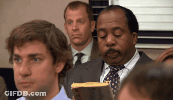 A Man In A Suit And Tie Is Holding A Book That Says Bible GIF