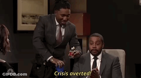 A Man In A Suit And Tie Is Holding A Bottle Of Alcohol And Says Crisis Averted GIF