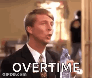A Man In A Suit And Tie Is Holding A Bottle Of Water In His Hand . GIF