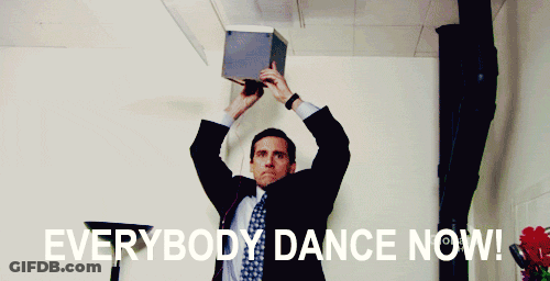 A Man In A Suit And Tie Is Holding A Box Over His Head With The Words " Everybody Dance Now " Above Him GIF